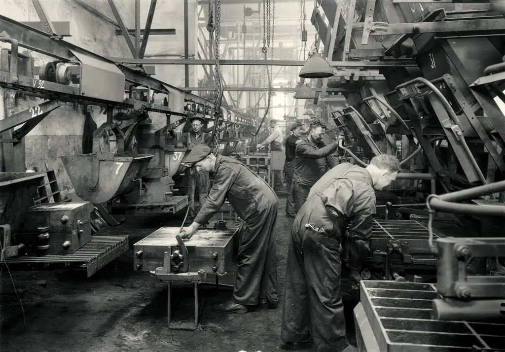 Photo noir et blanc d'ouvriers travaillant sur des machines de moulage dans l'ancienne usine Jøtul