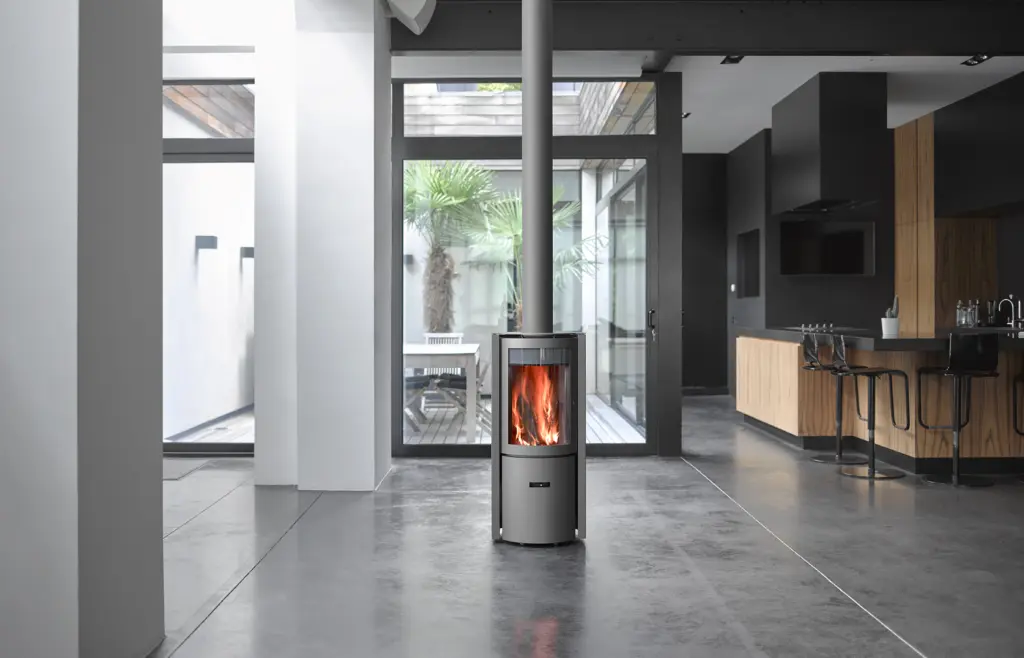 Galerie presse Stûv, visuel « Stûv 30-compact », poêle en situation dans un loft, porte vitrée, vue de face.