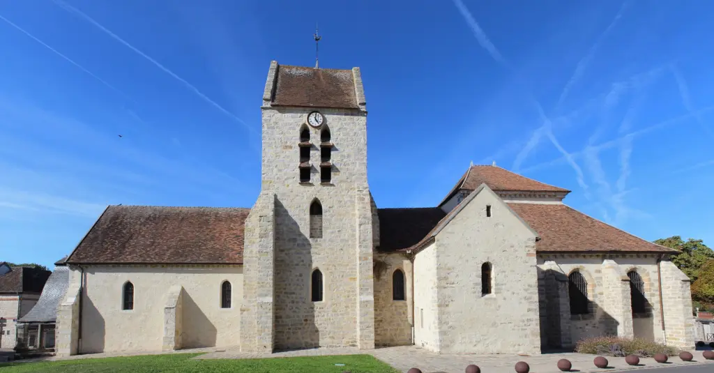 L’église Saint-Pierre d’Avon, clocher roman et nef de pierre claire, sous un ciel bleu.