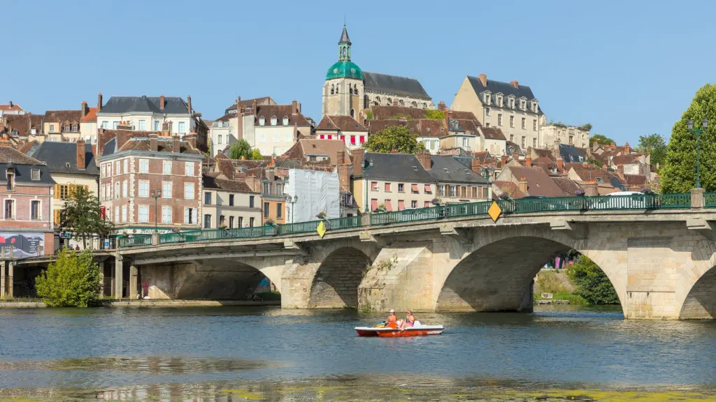 Joigny vue depuis le quai de la Butte : le pont sur l’Yonne et la vieille ville étagée sur la colline.