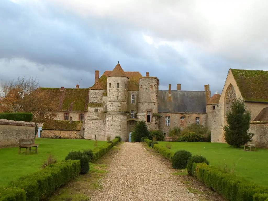Le château de Piffonds, ses tours rondes au bout d’une allée bordée de buis.