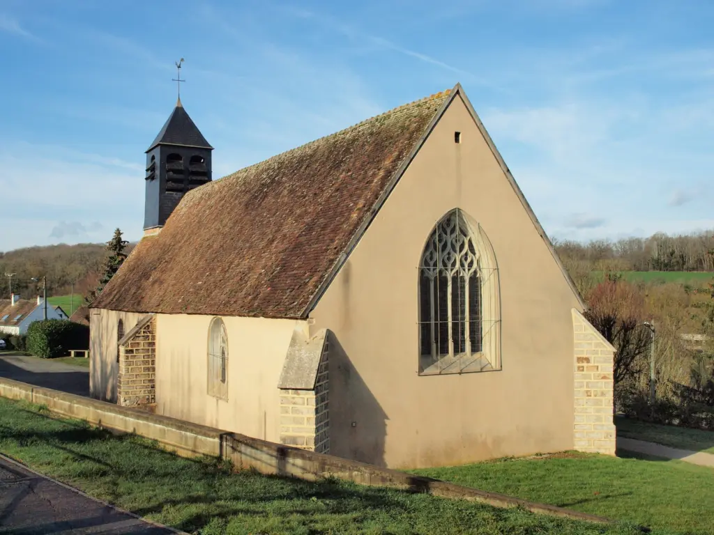 L’église Notre-Dame de Subligny, sa grande verrière gothique et son clocher, au soleil.