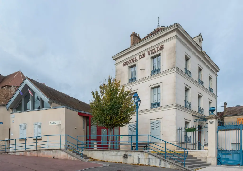L’hôtel de ville de Villeneuve-la-Guyard, haute façade blanche à l’angle de la rue.